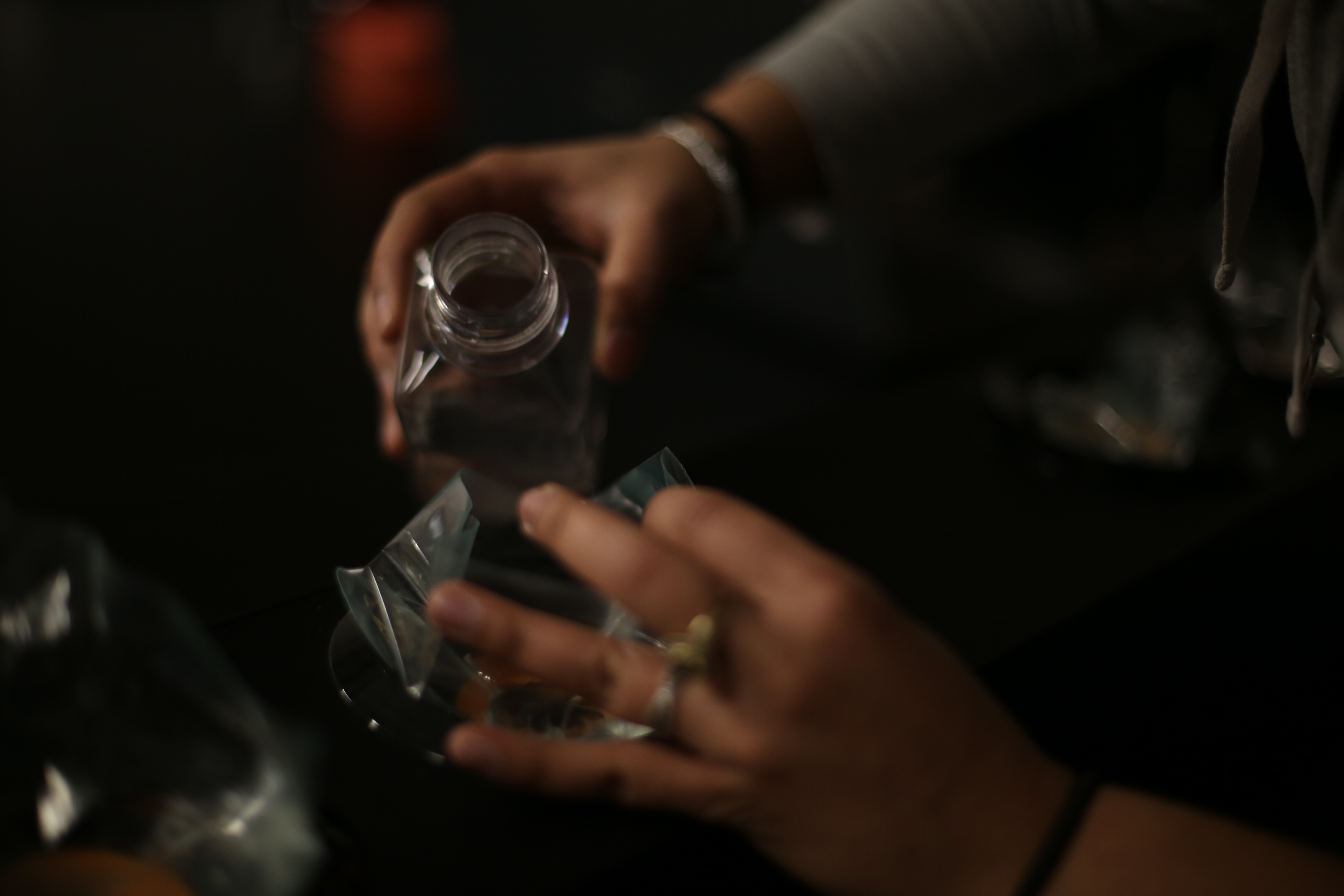 pouring the glowing pyrocystis from the bottle into bags.