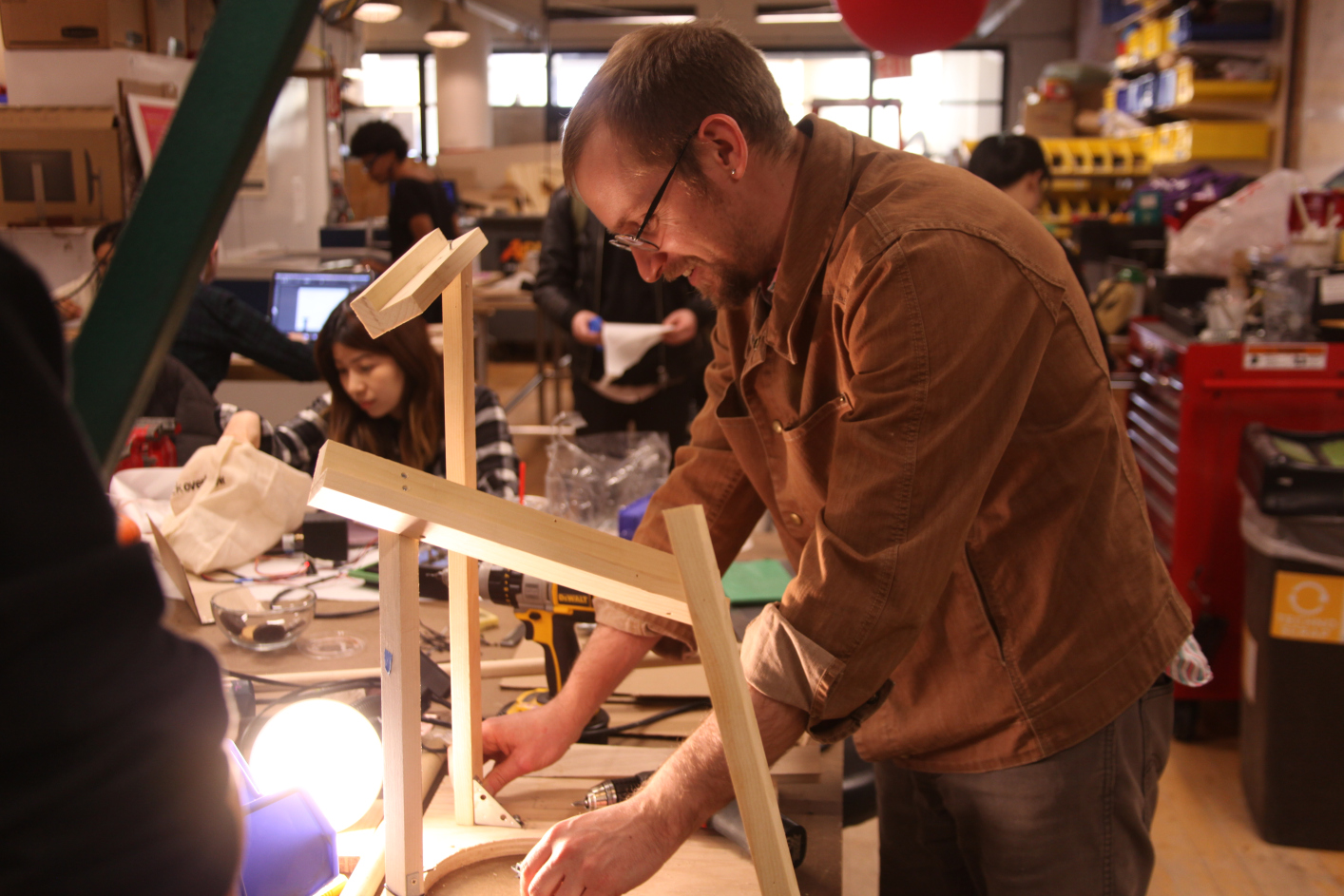 one student working on a wooden sculpture which is part of the rube goldberg machine
